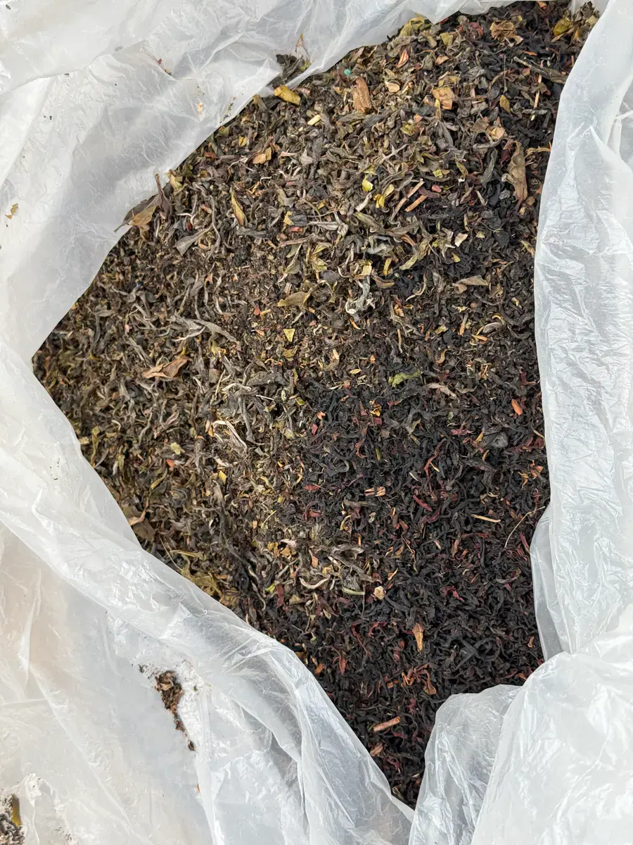 A large open bag filled with loose sun-dried maocha
